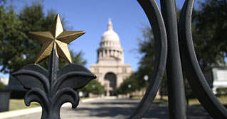 Far away photo of Texas Capitol from outside gate with gold star